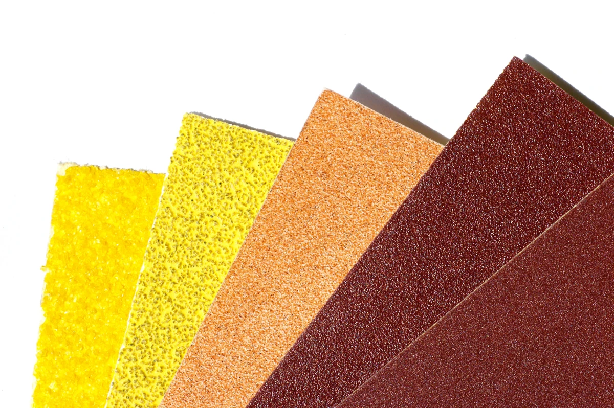 Overlapping sheets of differently coloured sandpaper