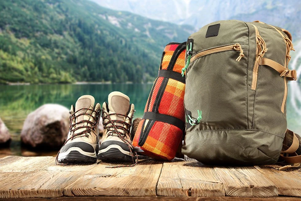 Backpack, footwear and rolled mat in an outdoor still life