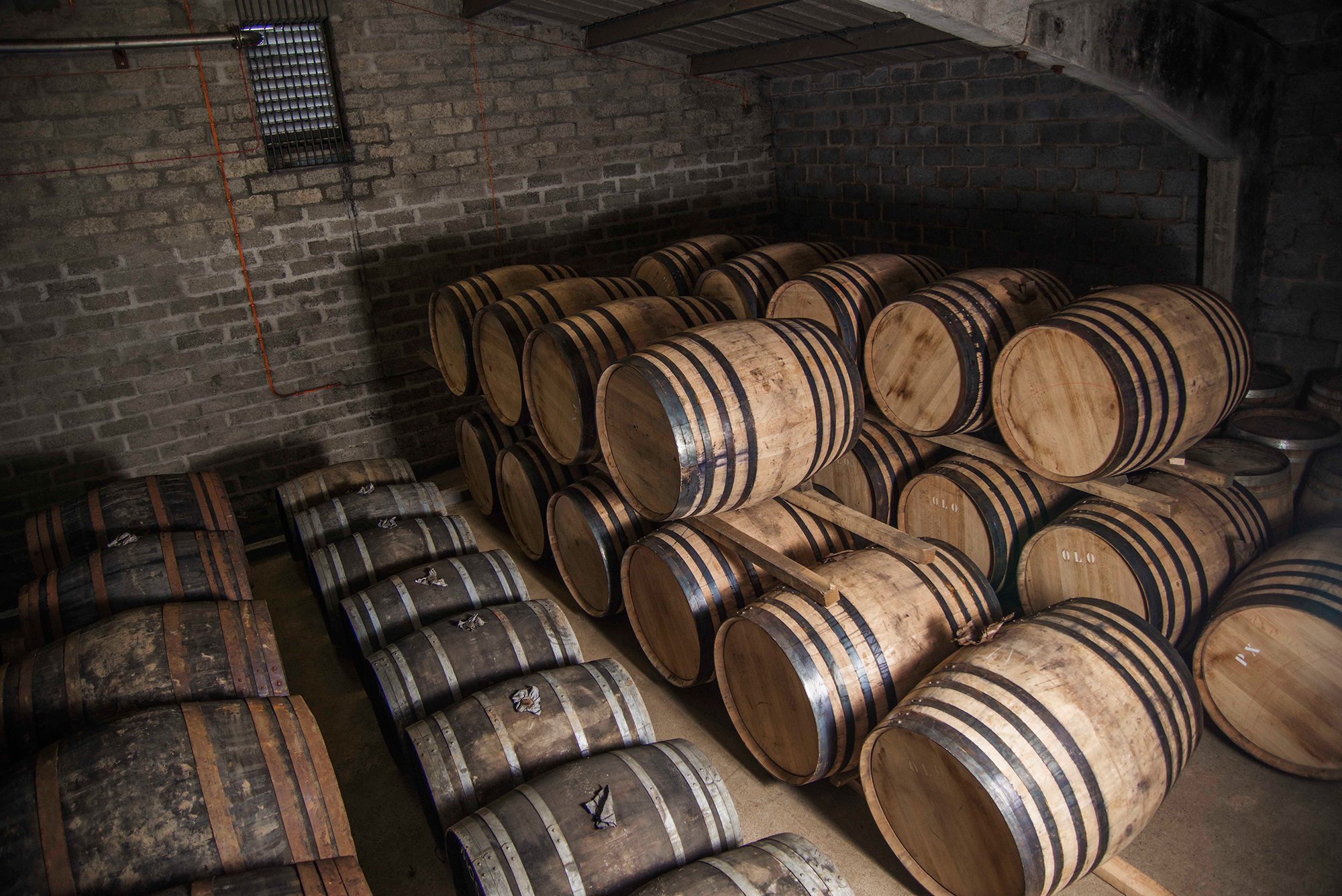Casks stacked inside a warehouse in the source photograph