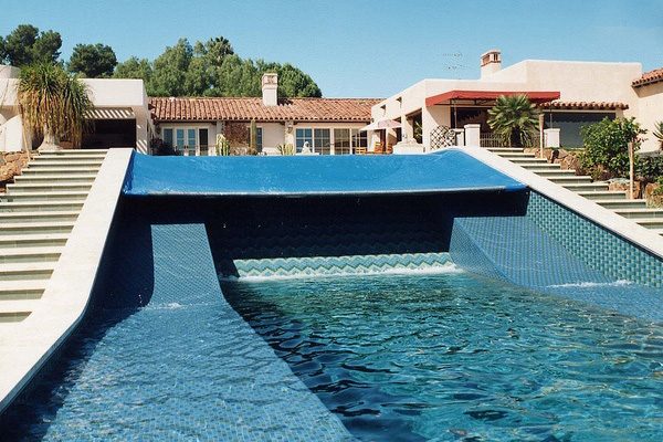 A blue pool cover extending across part of an outdoor pool