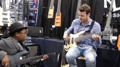 Michael Thurber and another musician playing electric basses at NAMM